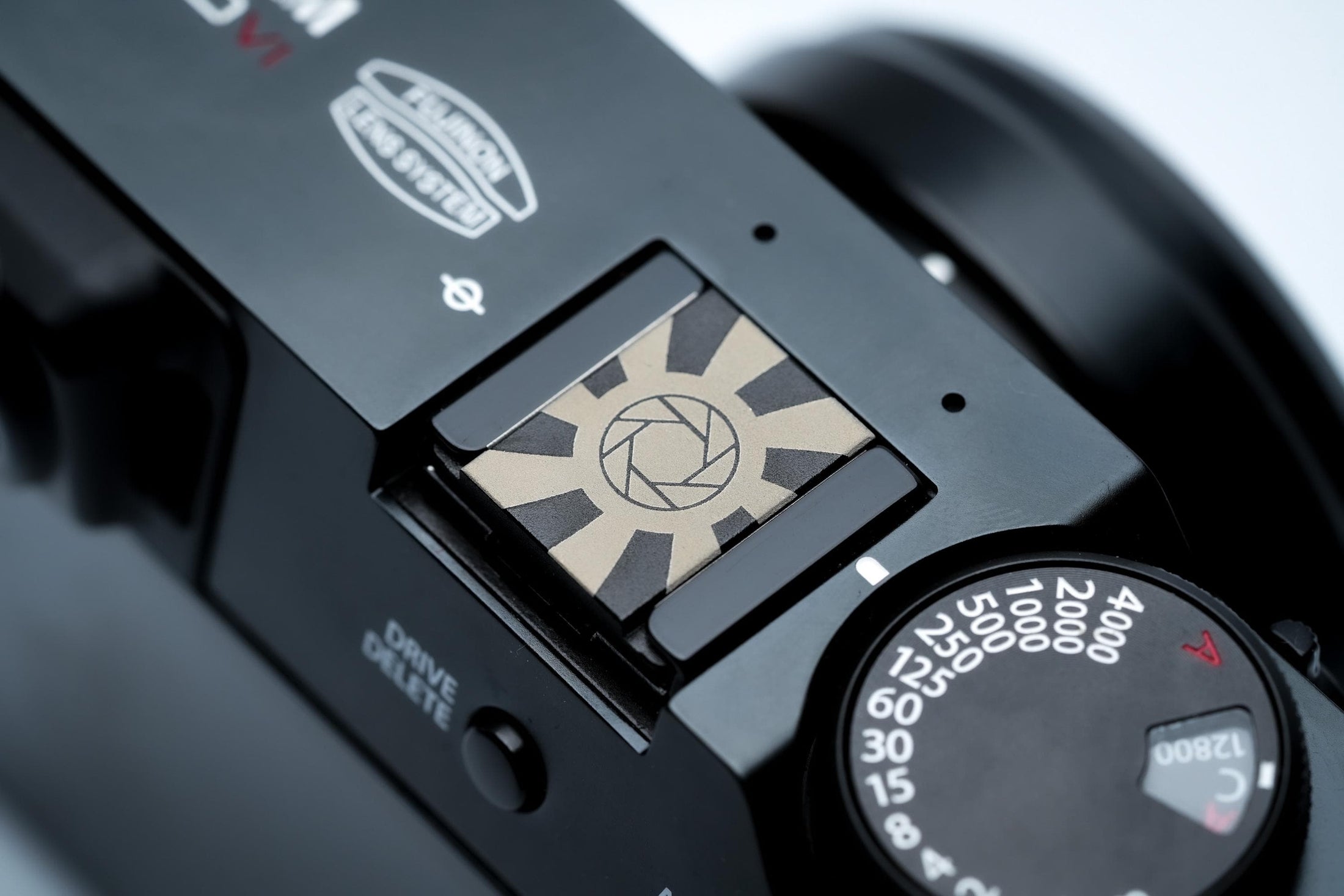 Hotshoe cover camera diafragma & zonnestralen – grafisch zwart aluminium ontwerp voor Fujifilm X100VI, Sony, Canon, Nikon en meer