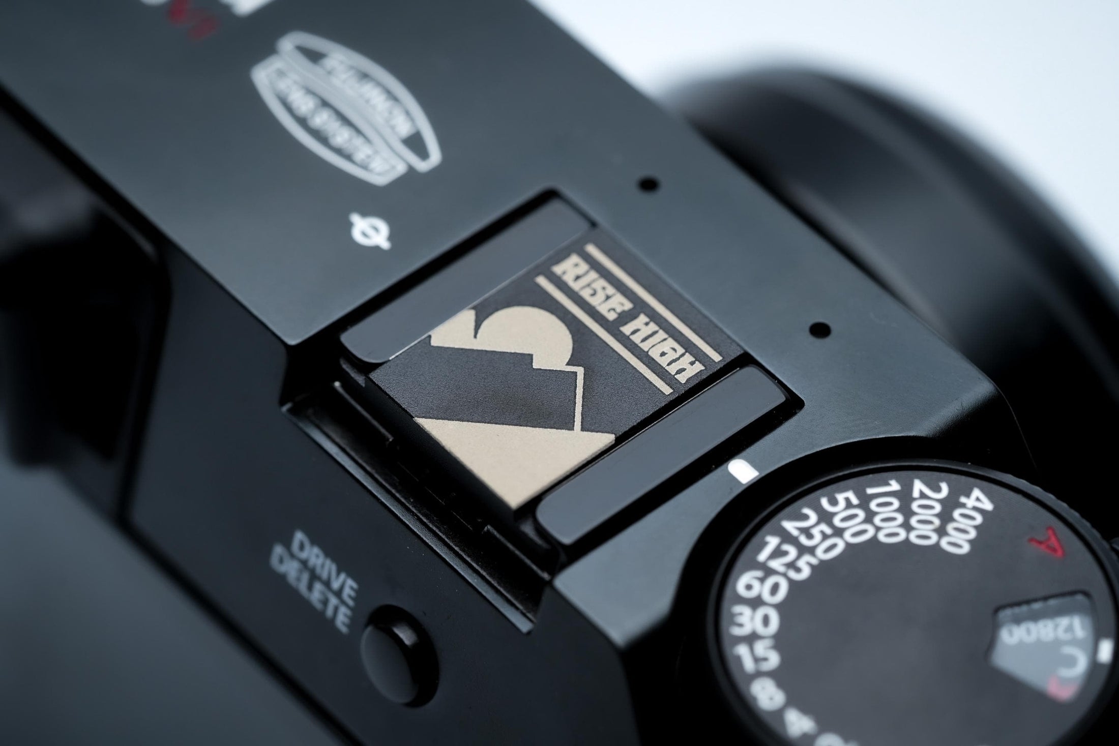 Hotshoe cover bergen & zon – "Rise High" gravure in zwart aluminium – berglandschap camera-accessoire voor Fujifilm X100VI, Sony, Nikon