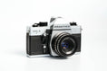 Load image into Gallery viewer, 'Praktica MTL 5 + Domiplan 50mm f/2.8 + free 35mm film – Reliable vintage SLR'
