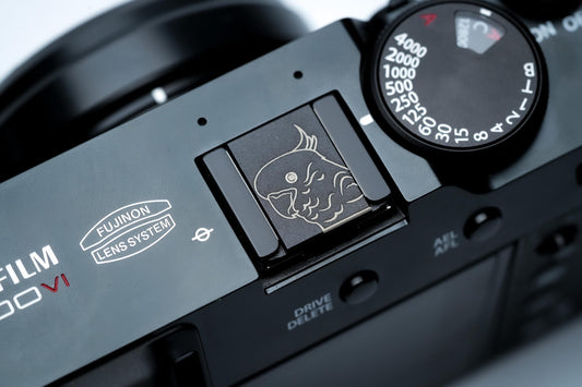 Hotshoe cover kaketoe – gegraveerd zwart aluminium – camera accessoire voor Fujifilm X100VI & vintage modellen by Unseend